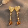 textured gold heart linear drop earrings with orange metal bead